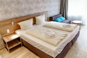 una habitación de hotel con dos camas y una silla en Haus am See Luxury HS 226 B, en Hahnenklee-Bockswiese