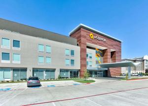 a building with a car parked in front of it at La Quinta Inn & Suites by Wyndham Dallas/Fairpark in Dallas
