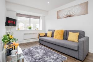 a living room with a gray couch and a window at Modernview Serviced Accommodation 1 Bedroom Watford HighStreet F10 in Watford