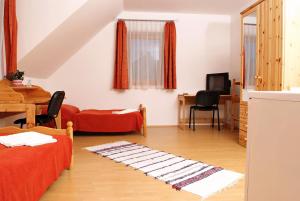 a room with two beds and a table and a dining room at Liszt Apartman in Pécs