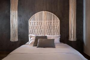 a bedroom with a large bed with a large headboard at Macrame Luxury Suites in Tríkala