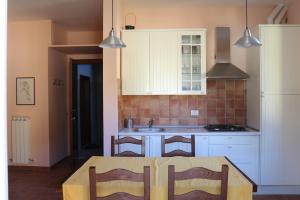 a kitchen with a table with chairs and a sink at Casa vacanze con balcone Valleremita - Analogic tour in Fabriano