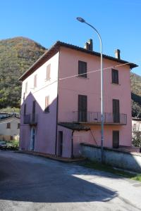un edificio rosa y blanco con luz de la calle en Casa vacanze con balcone Valleremita - Analogic tour, en Fabriano