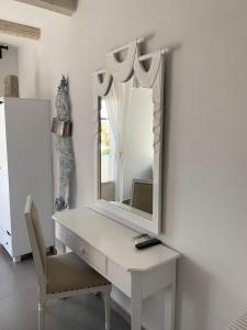 a dressing table with a mirror and a chair at Speires suites in Iraklia