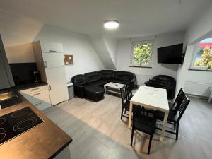 uma sala de estar com um sofá preto e uma mesa em HomesNRW - 2OG / City / Messe em Bergisch Gladbach