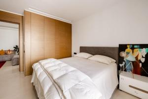 - une chambre avec un grand lit blanc et une tête de lit en bois dans l'établissement Lovely "Findy 101" with free parking, à Rabat
