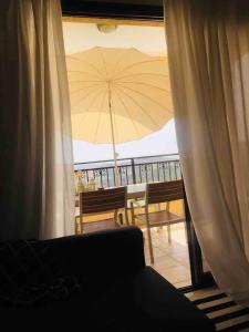 a view of a patio with an umbrella from a window at Aphrodite Gardens in Pissouri