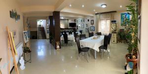 a dining room with a white table and black chairs at Casa Amurg in Sinaia