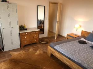 1 dormitorio con cama, tocador y espejo en Weitblick, en Sankt Augustin