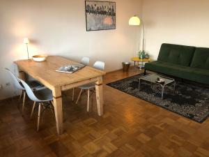 a living room with a wooden table and a green couch at Weitblick in Sankt Augustin