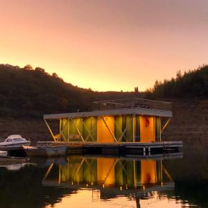 a house on a dock on a body of water at Floating Álvaro in Alvaro
