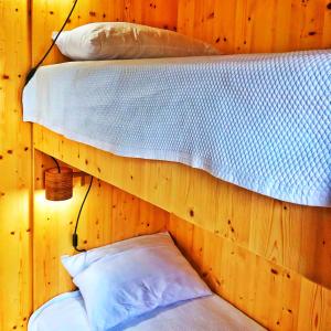 two bunk beds in a wooden room with two pillows at Floating Álvaro in Alvaro
