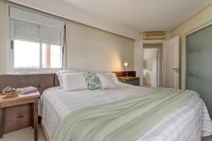 a bedroom with a large bed and a window at Triplex com jacuzzi na melhor vista de Floripa! in Florianópolis