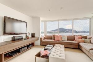 a large living room with a large flat screen tv at Triplex com jacuzzi na melhor vista de Floripa! in Florianópolis
