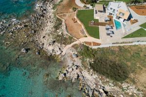 an aerial view of a house next to the ocean at An intimate Villa Resort- Right on the beach, by ThinkVilla in Petres