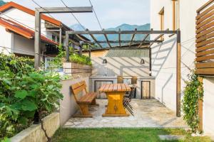 a patio with a wooden table and benches at Pr' Petrču in Tolmin