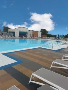 a large swimming pool with chairs and people on it at Tattershall Lakes Mini Breaks - Osprey Rise in Tattershall