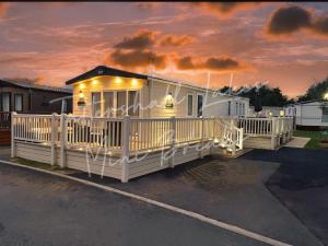 a mobile home with a porch and a deck at Tattershall Lakes Mini Breaks - Osprey Rise in Tattershall