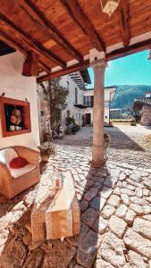 an outdoor patio with a stone floor and a wooden roof at Affittacamere Valnascosta in Faedis