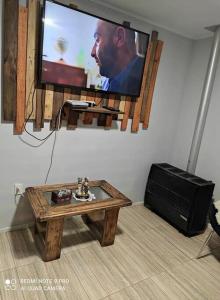 uma sala de estar com uma televisão e uma mesa de centro em Casa 5-6 Personas Puerto Natales em Puerto Natales