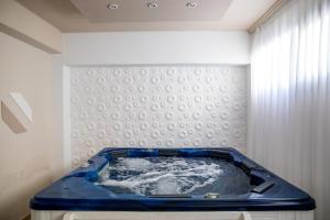 a blue tub in a room with a curtain at Skopelos Holidays Hotel & Spa in Skopelos Town