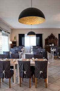a dining room with tables and chairs and a large chandelier at Skopelos Holidays Hotel & Spa in Skopelos Town