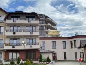 an apartment building with an umbrella on the balcony at Apartman Pahuljica in Kopaonik