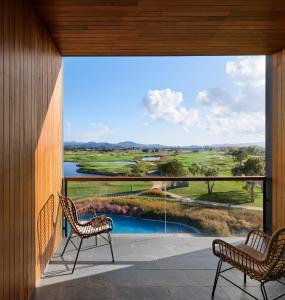 a view from the balcony of a house with two chairs at Empordà Golf Resort in Torroella de Montgrí