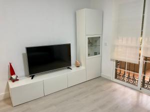 een woonkamer met een flatscreen-tv op een witte kast bij Las Arenas de la Carihuela in Torremolinos