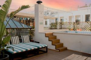 een bank op een balkon met een trap bij Oasis Backpackers' Hostel Sevilla & Coworking in Sevilla