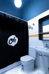 a white toilet sitting next to a bathroom sink at Oasis Backpackers' Hostel Sevilla & Coworking in Seville