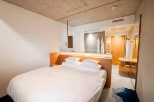 una camera con letto bianco e 4 cuscini di FIRMAMENT Hotel a Feldkirch