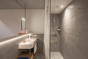un bagno con lavandino e doccia di FIRMAMENT Hotel a Feldkirch Altre 31 foto