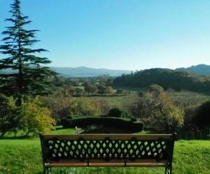 
a bench sitting in the middle of a lush green field at Plas Tan-Yr-Allt Historic Country House in Porthmadog
