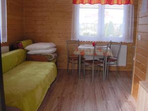 Habitación con mesa, sillas y sofá en Domki wypoczynkowe - całoroczne., en Wysowa-Zdrój