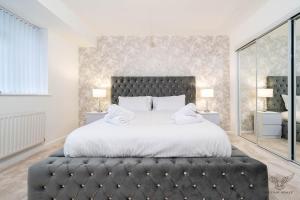 a bedroom with a large bed with a black headboard at WILLIAM HOMES - COOMBE ABBEY, Free Parking, King BED, NETFLIX & Pool Table in Coventry