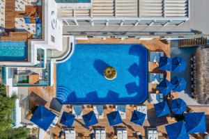 an overhead view of a resort pool with blue umbrellas at Meis Exclusive Hotel in Kaş