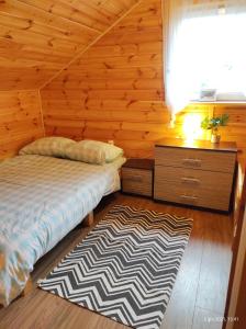 a bedroom with a bed and a rug on the floor at Wiejska Sielanka noclegi Ustroń in Ustroń