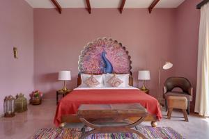 a bedroom with a large bed with a peacock headboard at Maya Garh Pushkar in Pushkar