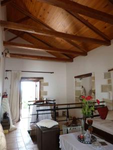 a living room with wooden ceilings and a table at The Garden Villas in Maleme