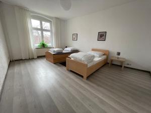 1 dormitorio con 2 camas y ventana en Tränental 4.2 en Staßfurt