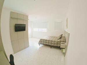 Habitación blanca con cama y ventana en Makaha Exclusive Suítes en Praia do Rosa