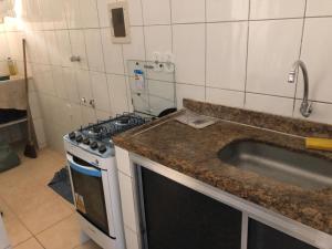 a kitchen with a stove and a sink at Jo´s Apartment in Porto Seguro