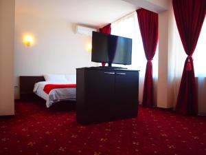 ママイアにあるHotel Marieのテレビ、ベッドが備わるホテルルームです。