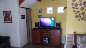 TV en la parte superior de una cómoda de madera en Brisas de San Antonio en San Antonio de Arredondo
