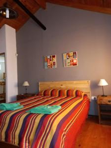 1 dormitorio con 1 cama con una manta a rayas de colores en Brisas de San Antonio en San Antonio de Arredondo
