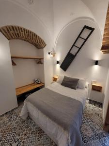 1 dormitorio con 1 cama grande en una habitación blanca en Casa Cuna, en Arcos de la Frontera
