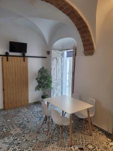 a dining room with a table and chairs and a door at Casa Cuna in Arcos de la Frontera