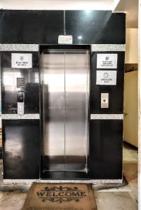 a large metal elevator in a building with signs on it at Raj Mahal Hotel in Nagpur