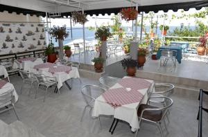 a restaurant with white tables and chairs and flowers at Sunset Studios in Skala Marion